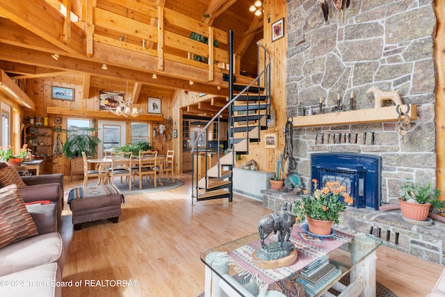 581 E Fork Rd, Dubois, WY 82513 - living room featuring stairway, wood walls, high vaulted ceiling, wood finished floors, and a stone fireplace