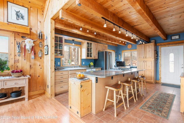 581 E Fork Rd, Dubois, WY 82513 - kitchen with freestanding refrigerator, track lighting, a wood ceiling with exposed beams, a kitchen island, and a breakfast bar area