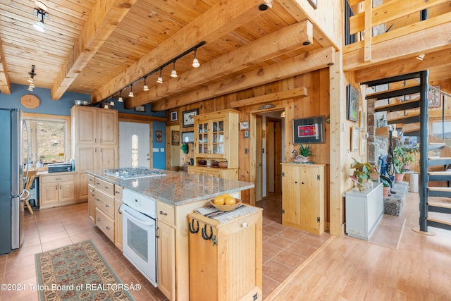 581 E Fork Rd, Dubois, WY 82513 - kitchen with track lighting, oven, gas cooktop, a wooden ceiling with exposed beams, and freestanding refrigerator