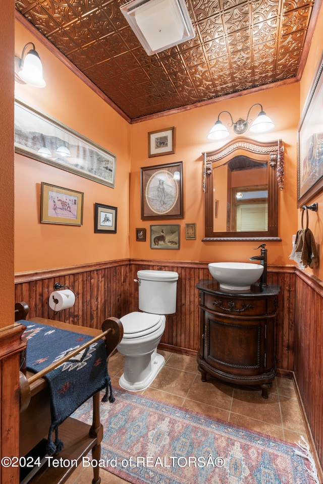 581 E Fork Rd, Dubois, WY 82513 - half bath featuring an ornate ceiling, wainscoting, vanity, wooden walls, and tile patterned flooring