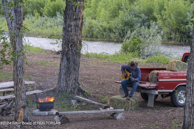581 E Fork Rd, Dubois, WY 82513 - view of yard with a forest view, a fire pit, and a water view