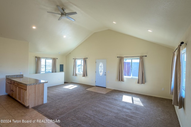 kitchen with lofted ceiling, ceiling fan, tile floors, and light brown cabinets