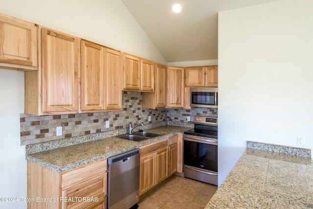 kitchen with stainless steel appliances, light tile flooring, lofted ceiling, tasteful backsplash, and sink