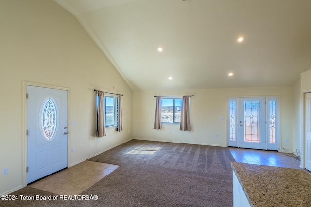 carpeted foyer with lofted ceiling