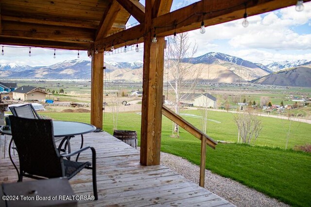 wooden terrace with a gazebo, a mountain view, and a yard