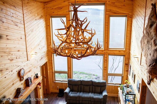 living room featuring wood walls, hardwood / wood-style floors, and a notable chandelier