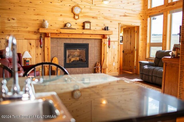 interior space featuring a tiled fireplace and wood walls