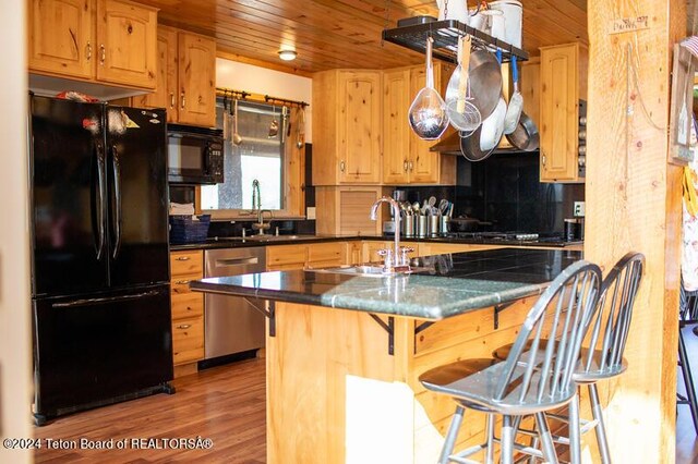 kitchen featuring black appliances, a kitchen breakfast bar, wooden ceiling, and light hardwood / wood-style flooring