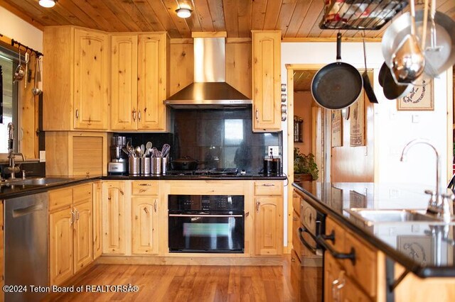 kitchen with wall chimney range hood, light hardwood / wood-style floors, dishwasher, oven, and sink