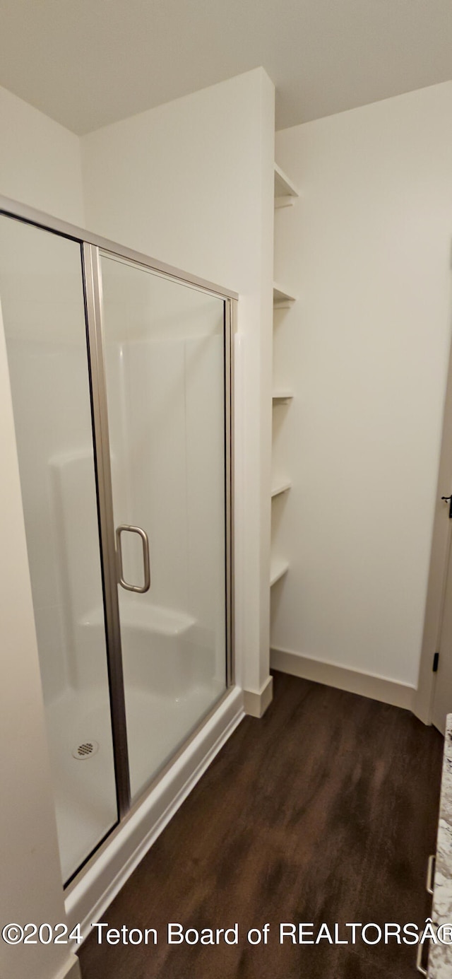 bathroom with wood-type flooring and an enclosed shower