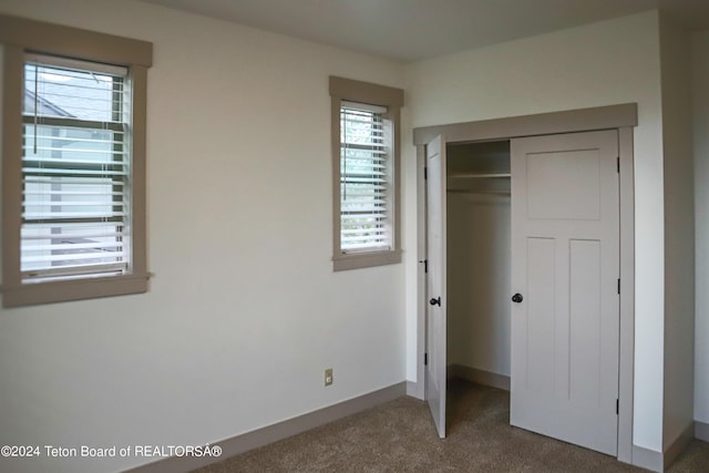 unfurnished bedroom featuring carpet and a closet