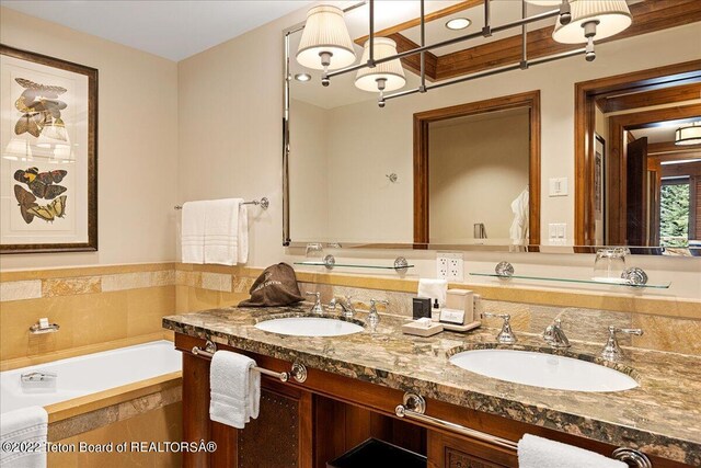 bathroom with a relaxing tiled bath and dual bowl vanity