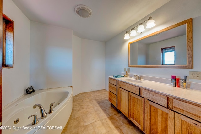 bathroom with tile flooring, vanity, and a tub