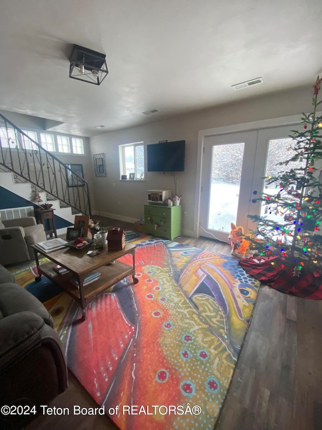 living room with hardwood / wood-style floors, a wealth of natural light, and french doors