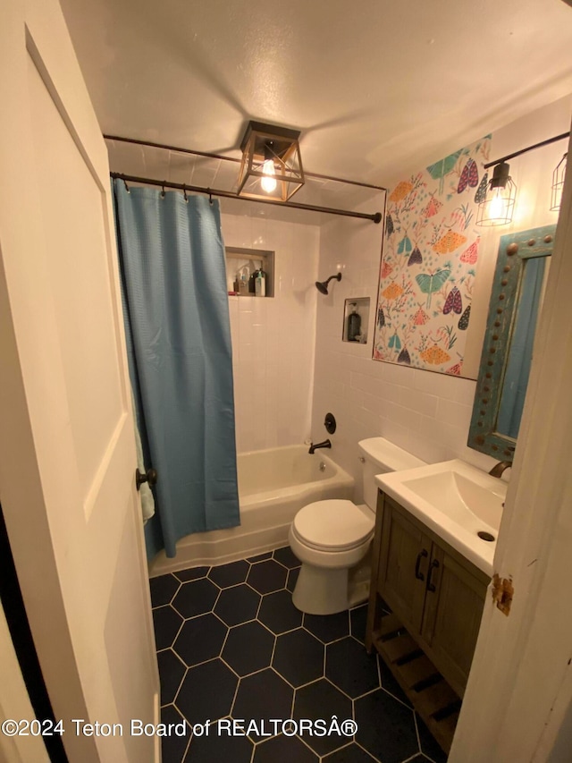 full bathroom with tile walls, vanity, shower / bath combo, tile patterned flooring, and toilet