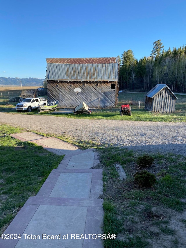 view of yard featuring a mountain view and an outdoor structure