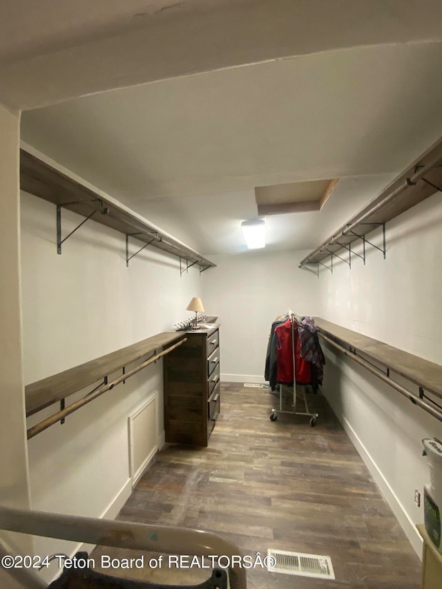 spacious closet with dark hardwood / wood-style flooring