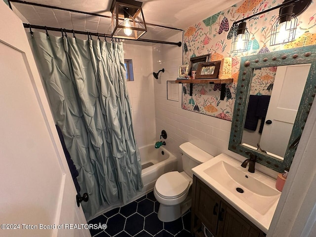 full bathroom featuring shower / bath combo with shower curtain, vanity, toilet, and tile walls