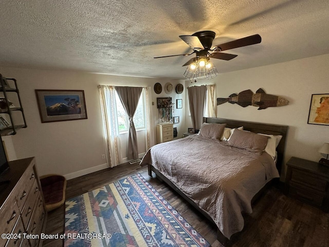 bedroom featuring a textured ceiling, dark wood-type flooring, and ceiling fan