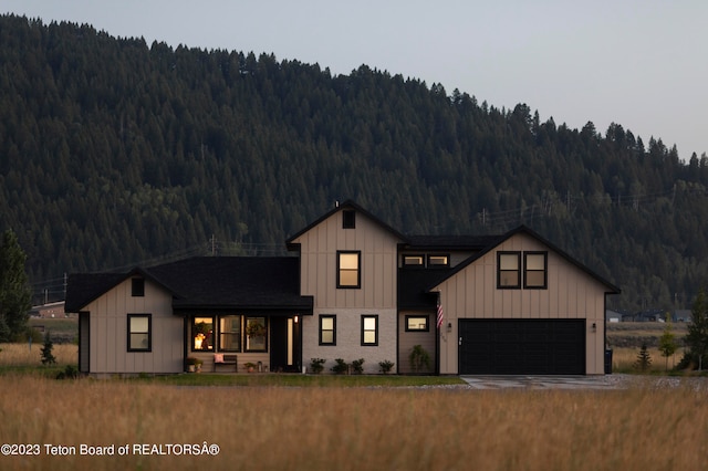 modern farmhouse with a mountain view and a garage