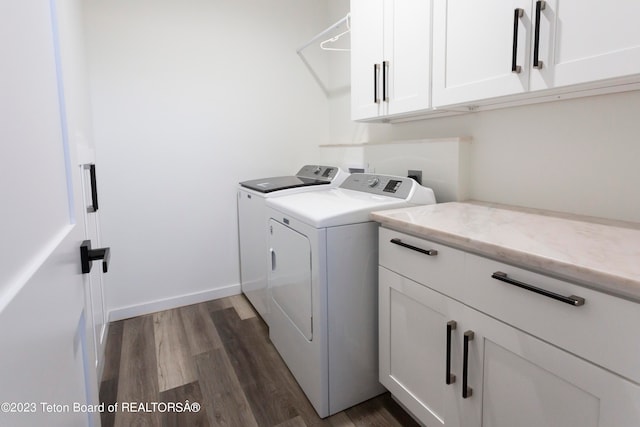 laundry area featuring washer and clothes dryer, dark hardwood / wood-style floors, and cabinets