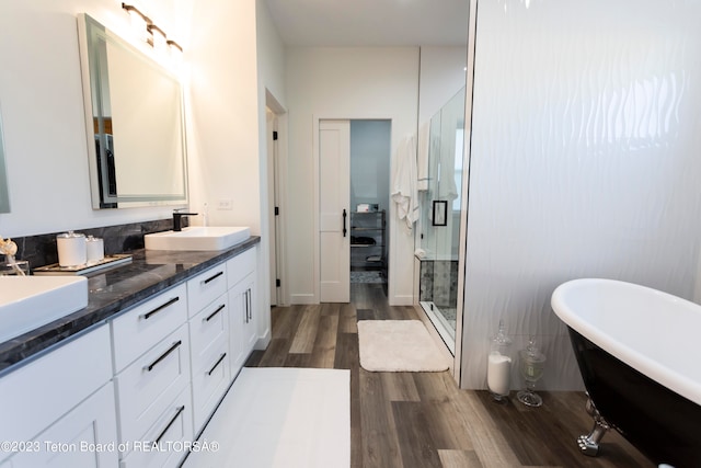 bathroom with hardwood / wood-style floors, vanity, and shower with separate bathtub