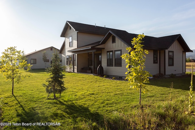 rear view of property featuring a lawn