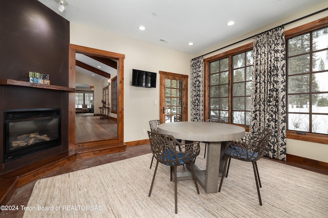 dining space featuring a large fireplace, vaulted ceiling, and plenty of natural light