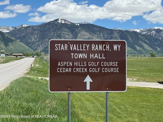 community / neighborhood sign with a mountain view