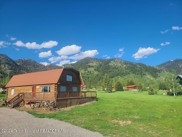 exterior space with a yard and a deck with mountain view