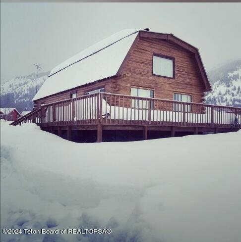 view of snow covered exterior featuring a wooden deck