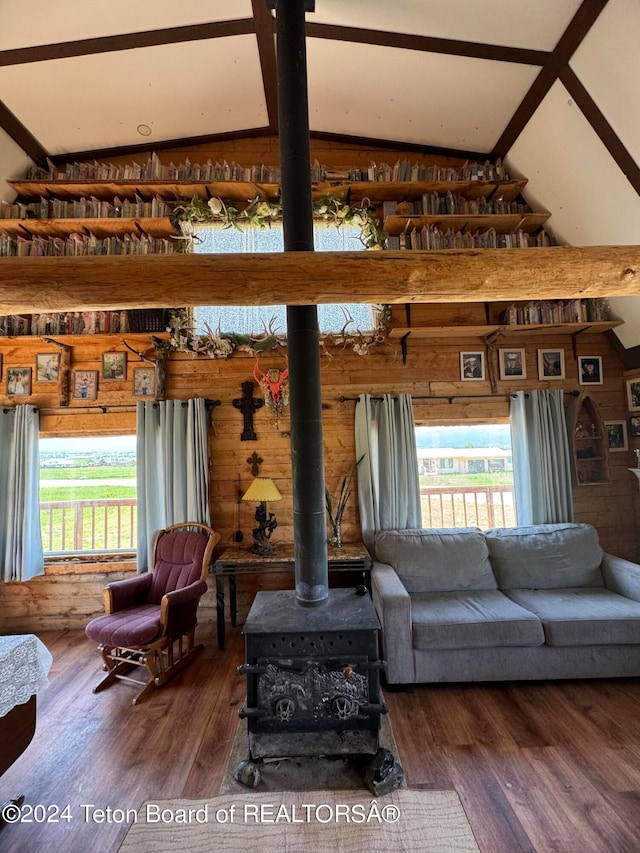 living room with vaulted ceiling with beams, a wood stove, and dark wood-type flooring