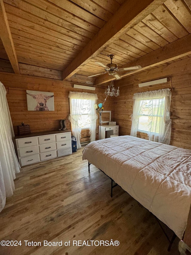 bedroom with beam ceiling, wooden walls, and hardwood / wood-style floors