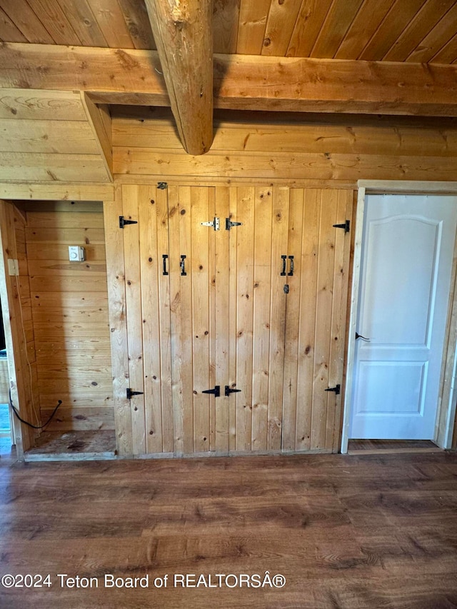 interior details featuring beam ceiling, wood ceiling, wood-type flooring, and wood walls