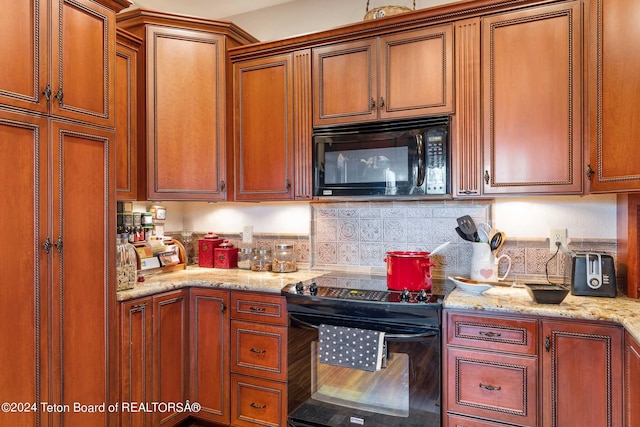 kitchen featuring black appliances, decorative backsplash, and light stone counters