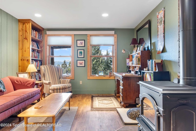 office area with a wood stove and light wood-type flooring