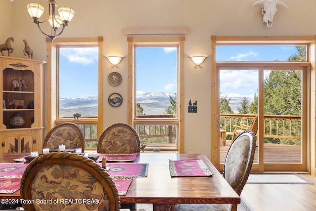 dining space featuring a wealth of natural light, a mountain view, hardwood / wood-style floors, and a chandelier