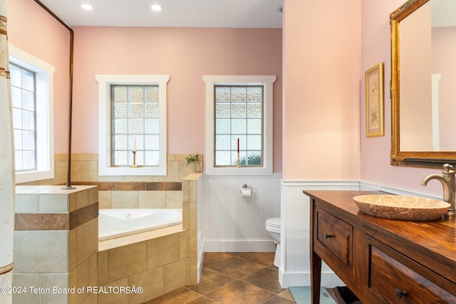 bathroom with tile patterned floors, plenty of natural light, toilet, and tiled tub