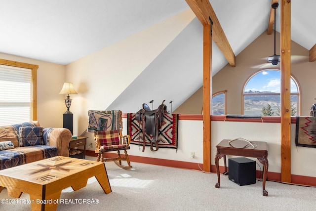 living area with vaulted ceiling with beams and light colored carpet