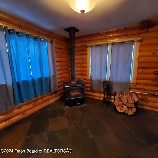 living area featuring a wood stove and log walls