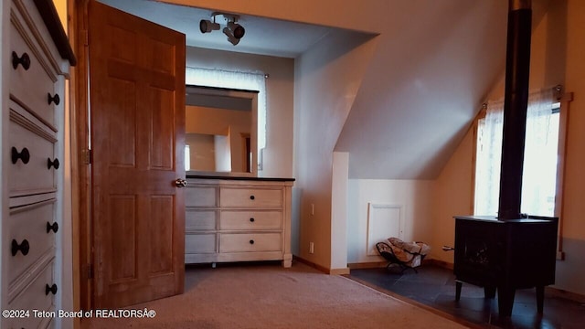 additional living space with lofted ceiling and dark colored carpet