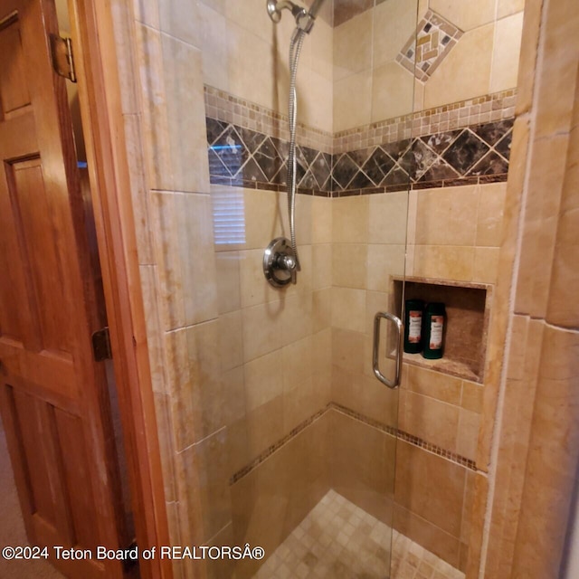 bathroom with a shower with door