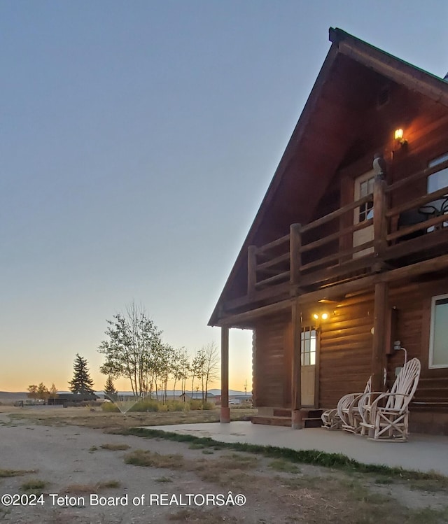 property exterior at dusk featuring covered porch