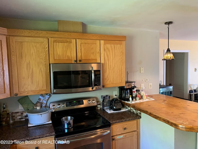 955 Budge Dr Unit 4, Jackson, WY 83001 - kitchen featuring appliances with stainless steel finishes, a peninsula, decorative light fixtures, and butcher block counters