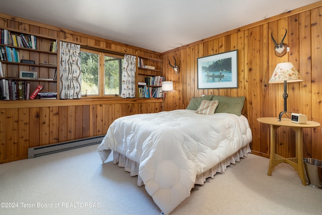 carpeted bedroom featuring wooden walls and a baseboard heating unit