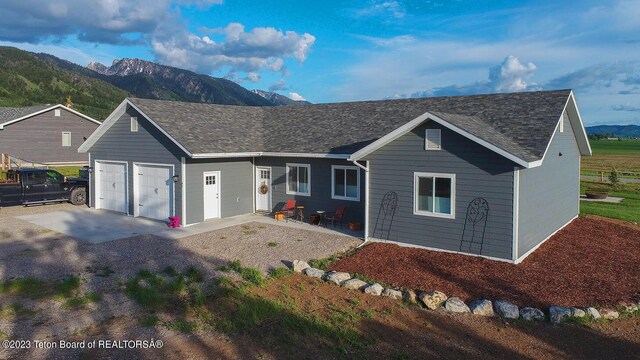 ranch-style house with a garage and a mountain view