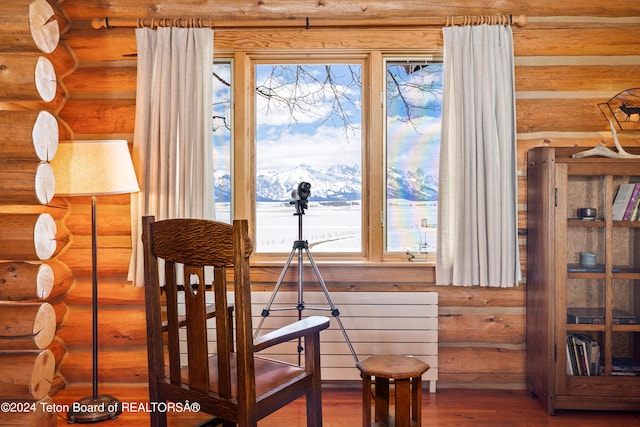 dining space with hardwood / wood-style flooring, rustic walls, and a mountain view