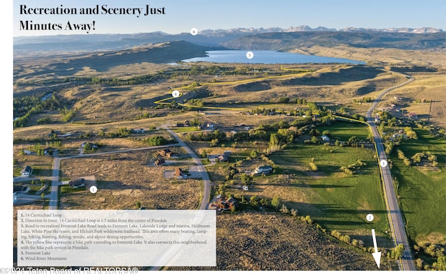 birds eye view of property with a water and mountain view