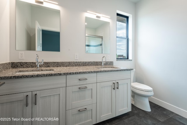 bathroom with vanity, toilet, and a shower with shower door