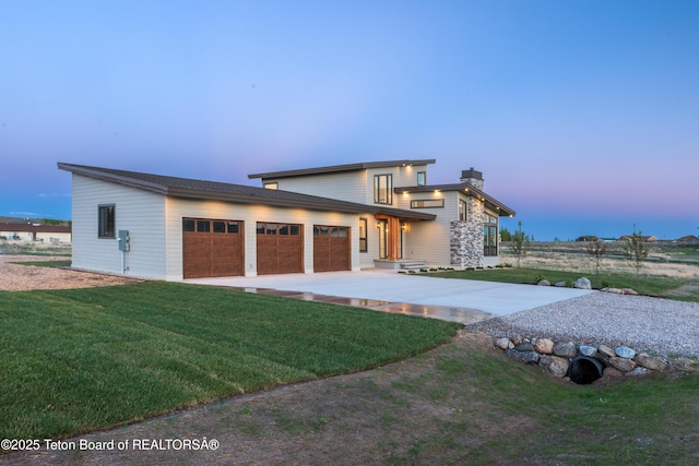 prairie-style home featuring a yard and a garage